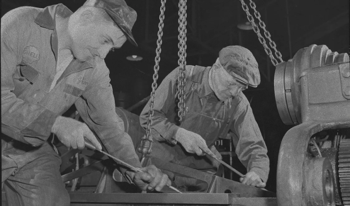 Factory machinists work with heavy machinery